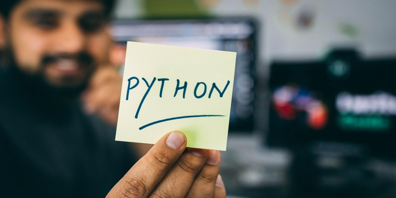 Die 7 besten Möglichkeiten, um zu lernen, wie man kostenlos kodiert - man holding python card