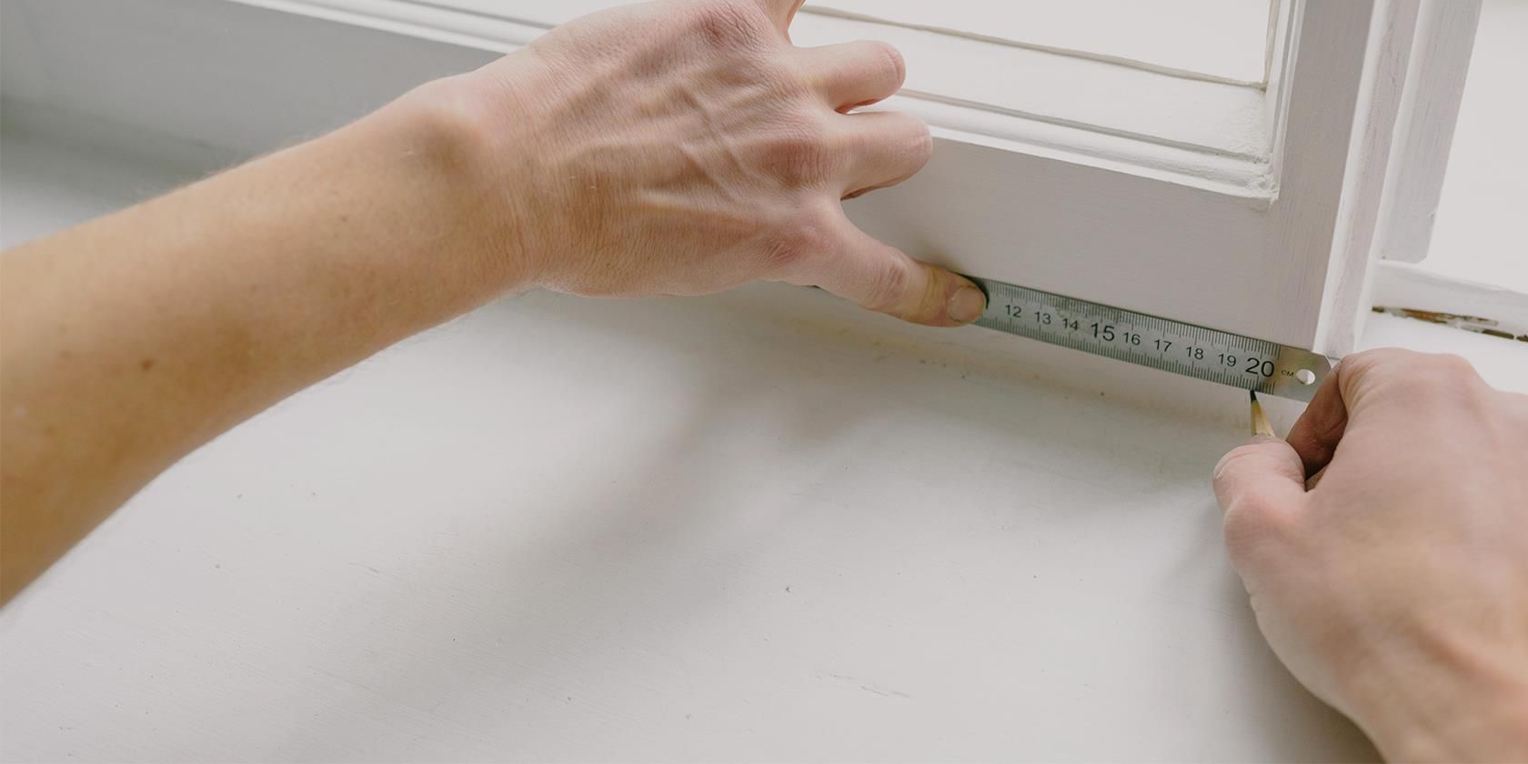 person-measuring-a-window-frame