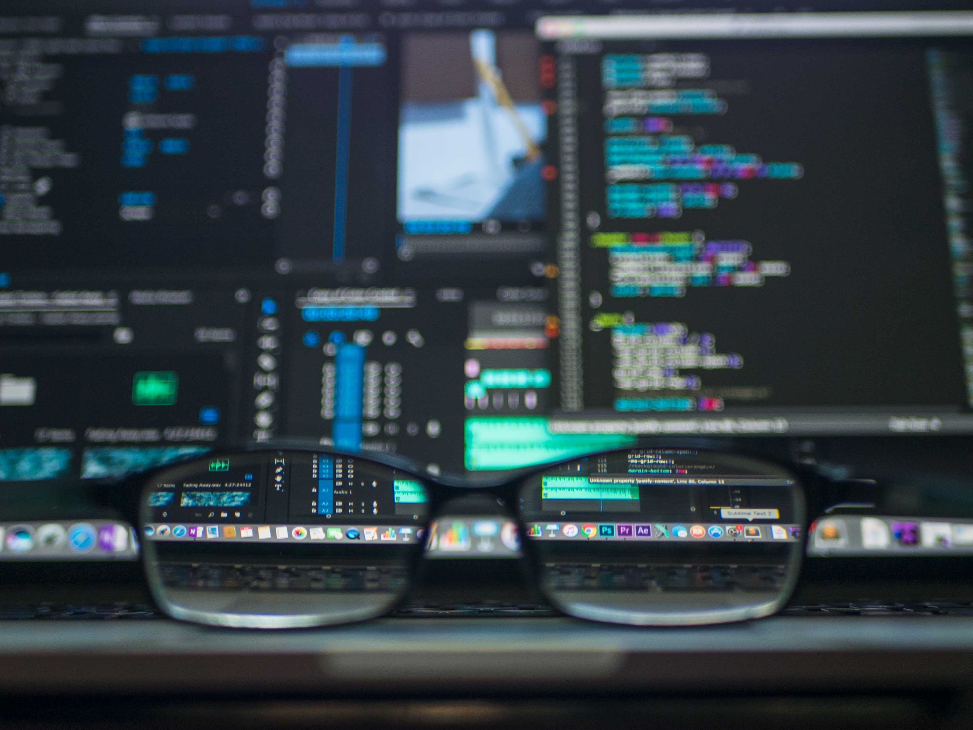 Glasses in front of screens of code