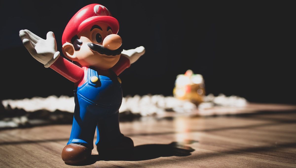 A Super Mario figure, standing on a brown table.