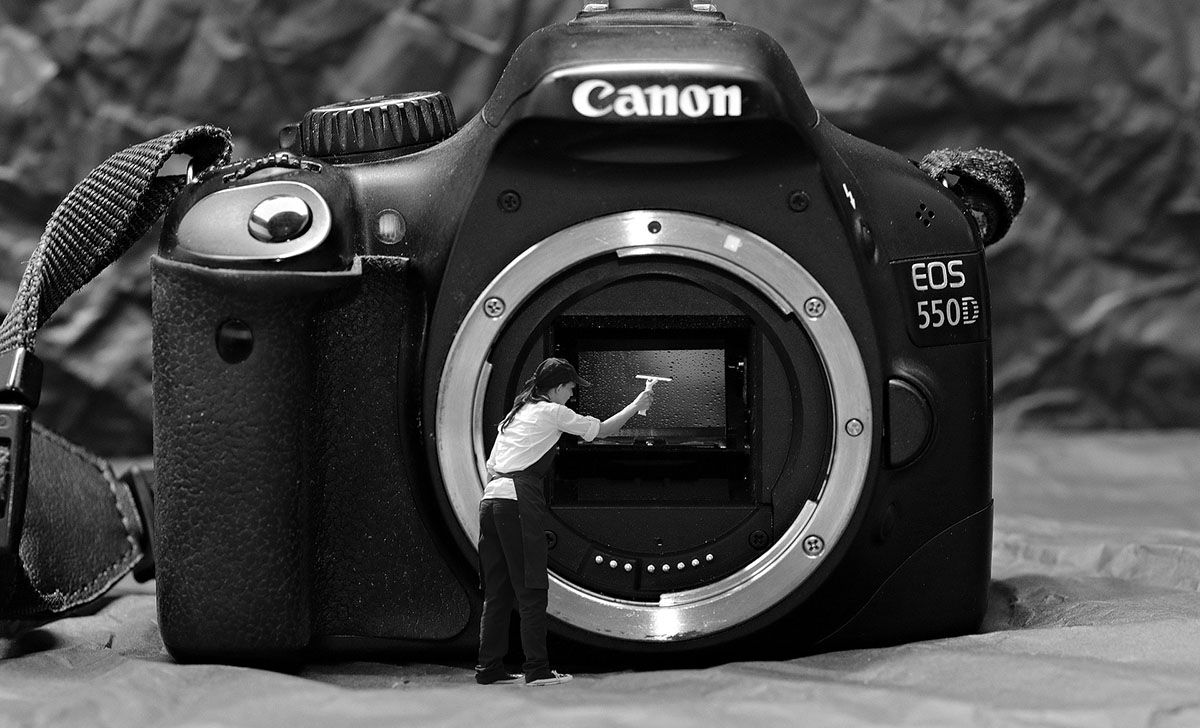 tiny person cleaning a camera