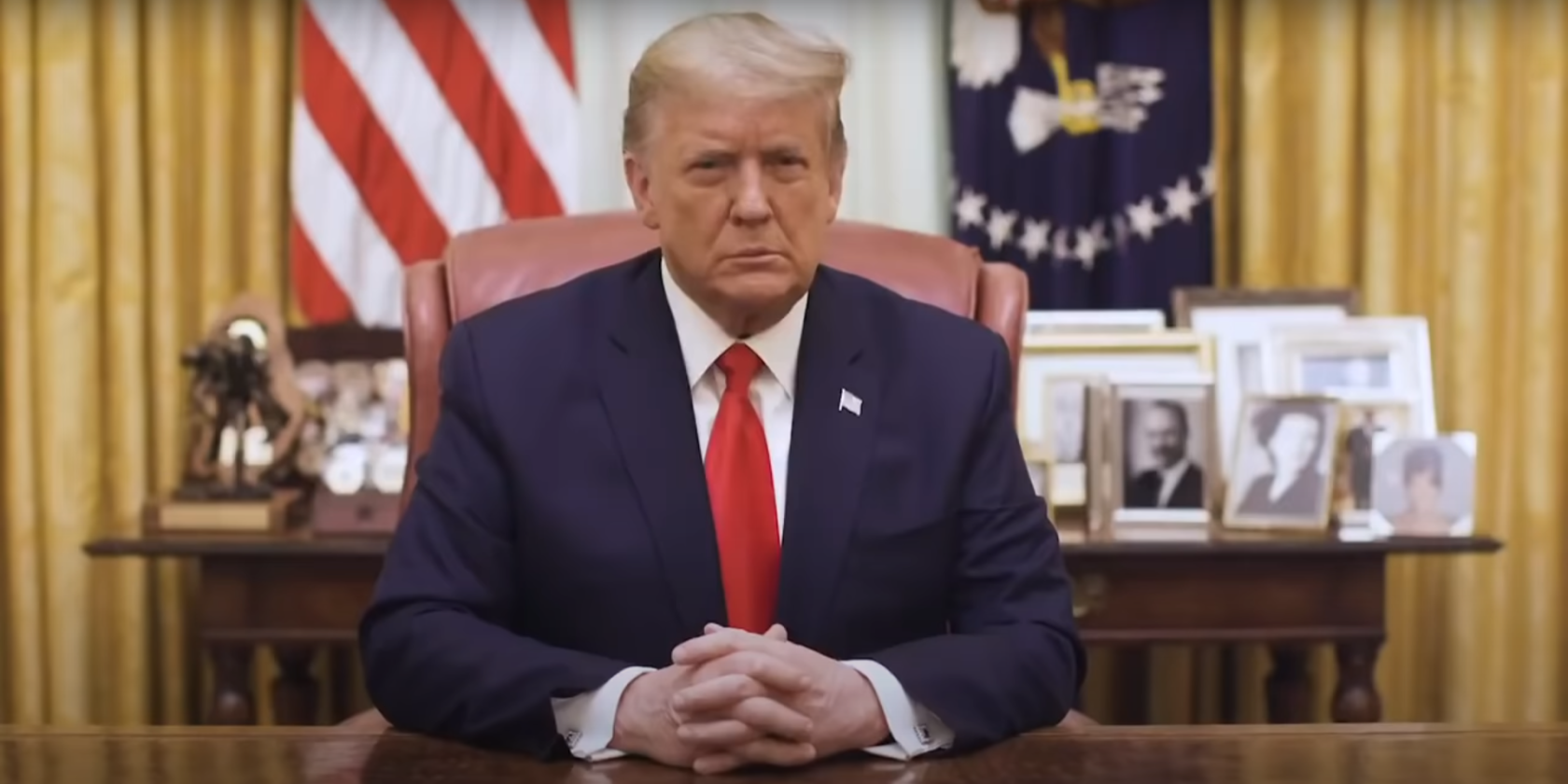 Trump sitting at a desk