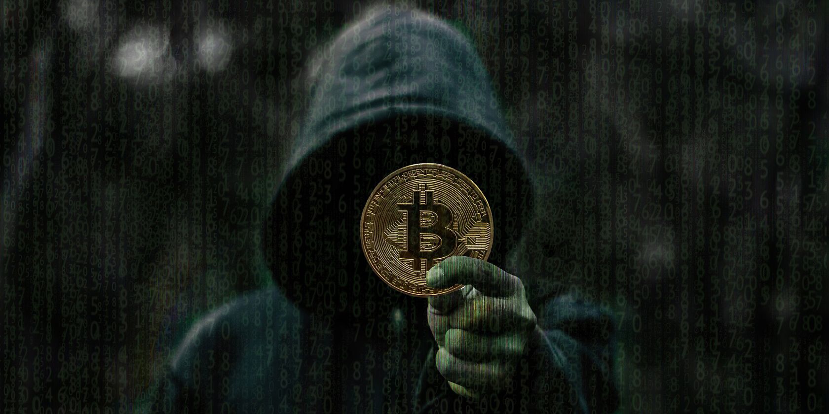 A man in hoodie holding a Bitcoin