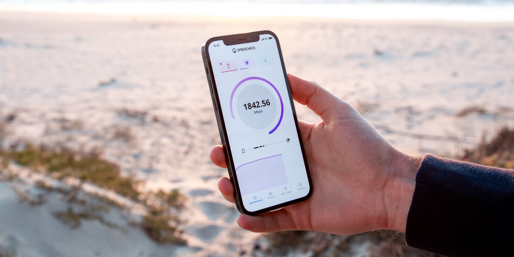 5G speeds shown in a speed test on an iPhone, with the beach in the background