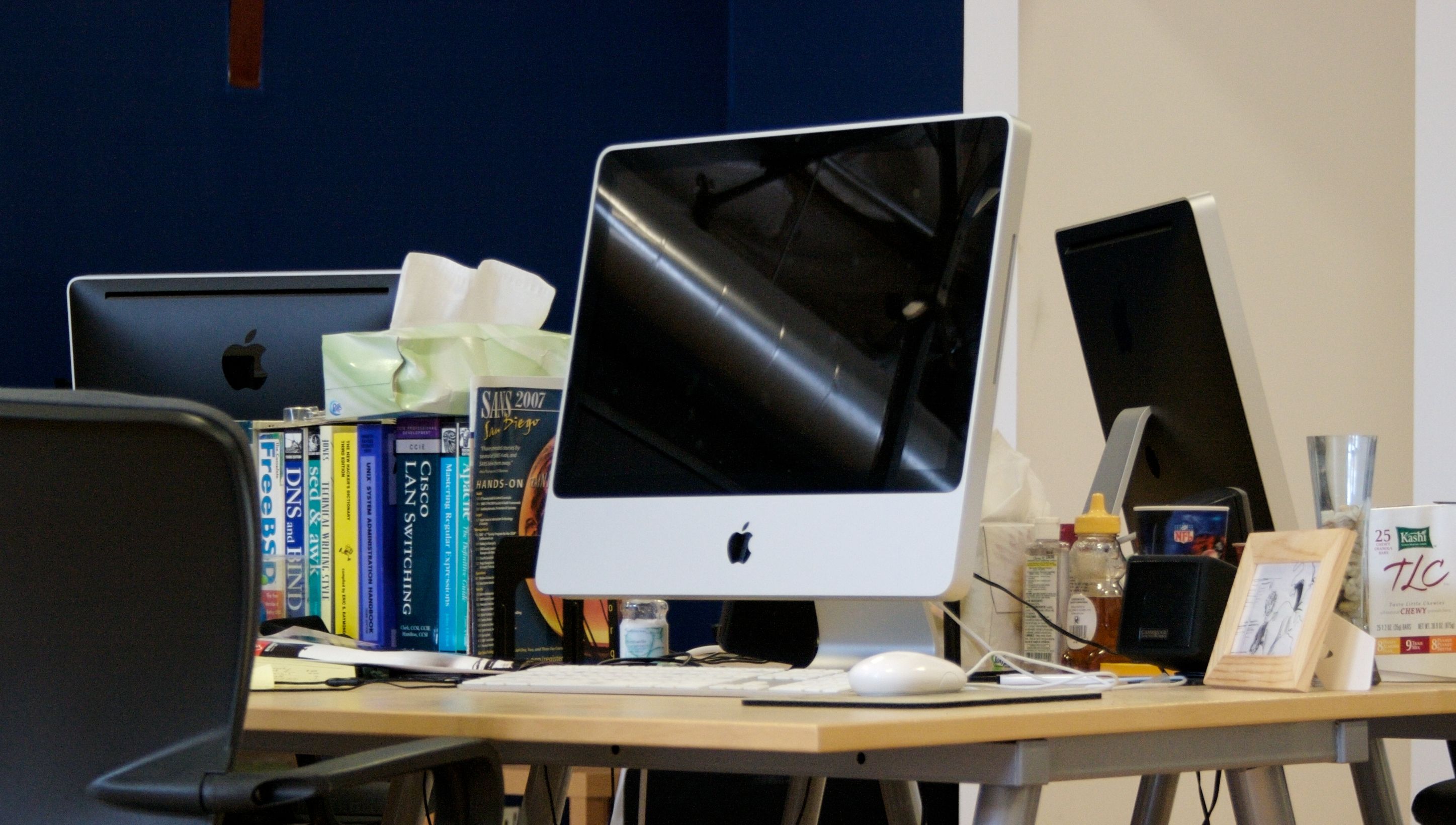 A 2008 Aluminum body iMac sits on a desk with other items
