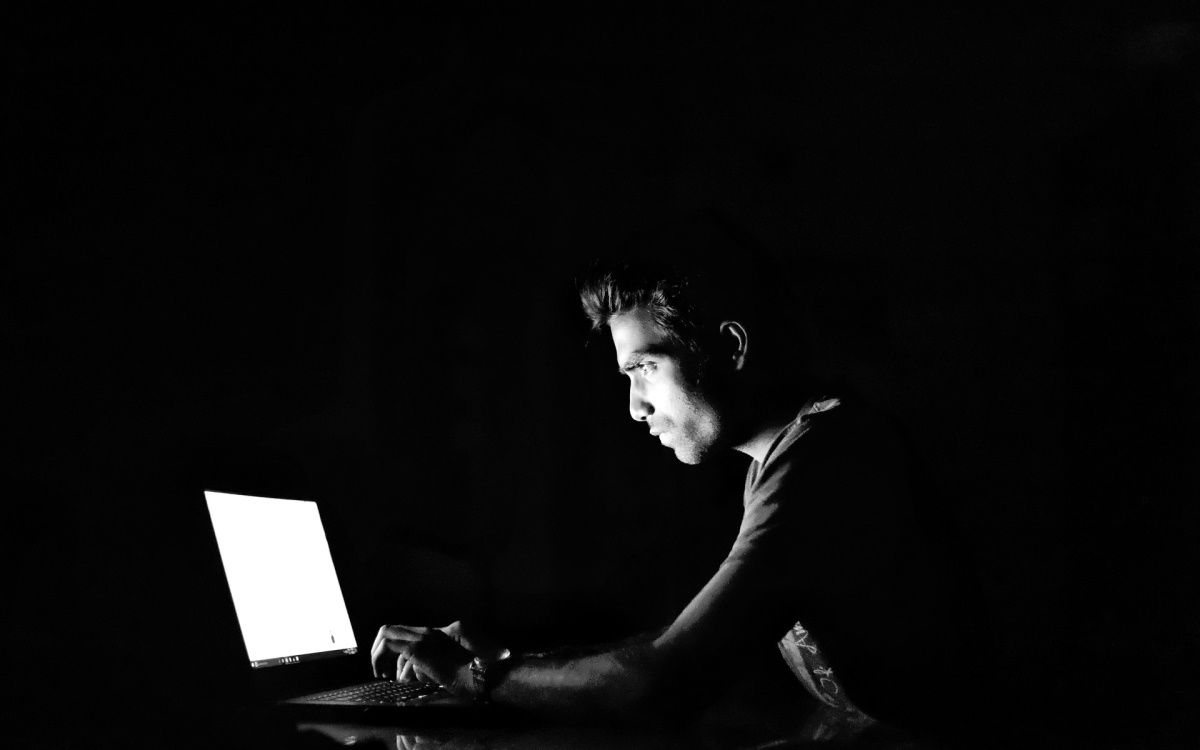 man using a laptop in dark room