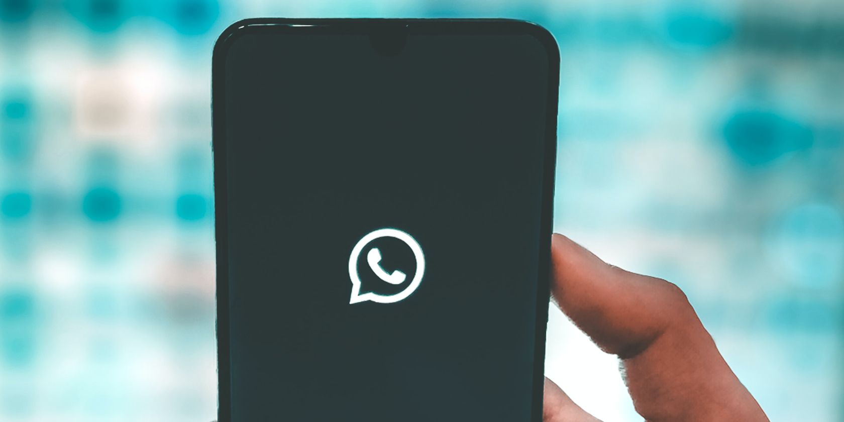 Close-up of the WhatsApp logo on a phone being held up