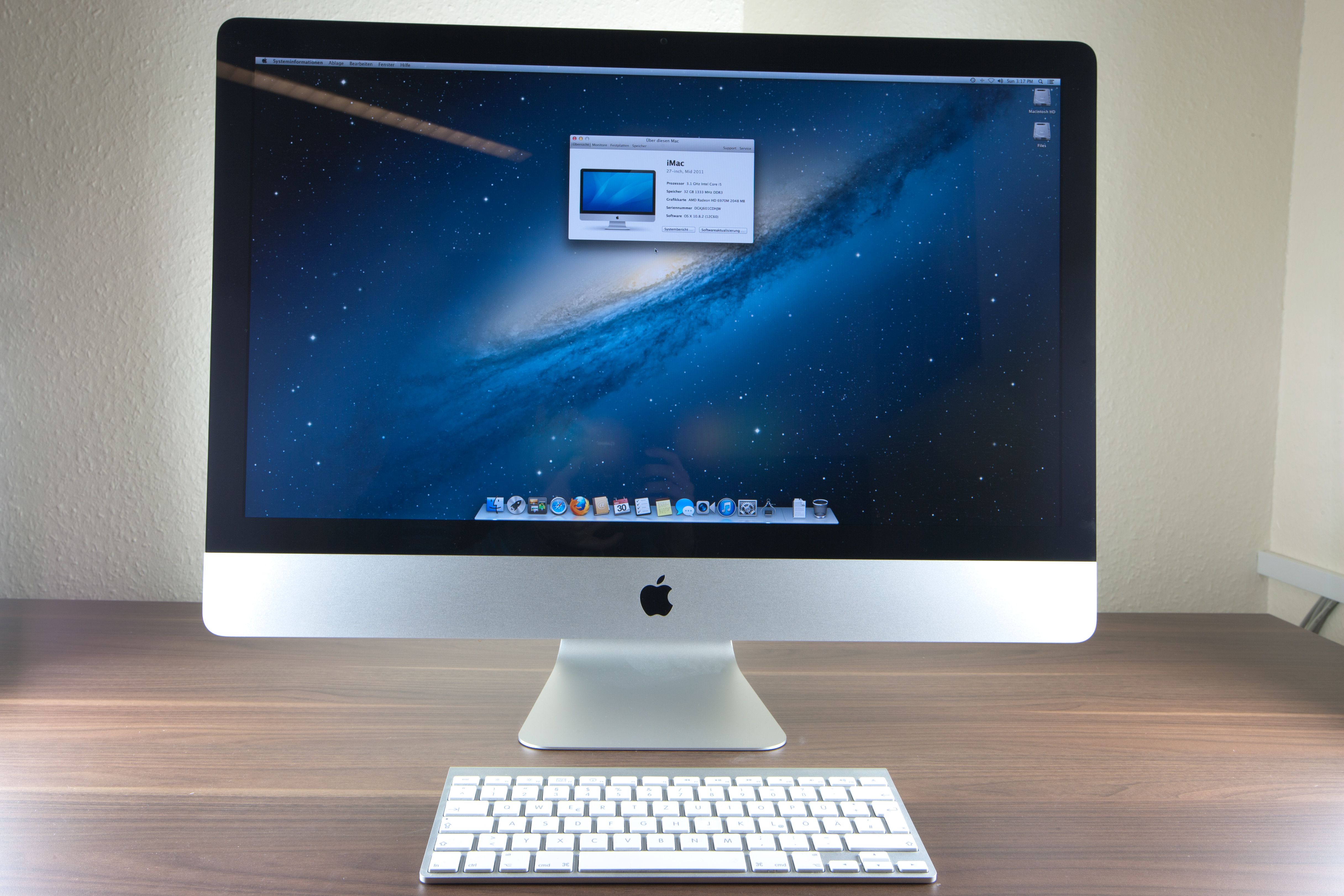 A slim 27" 2012 iMac sits on a desk with a keyboard in front of it