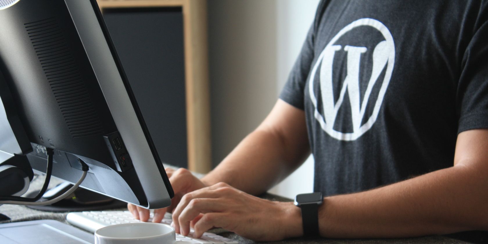 Person with WordPress shirt working at PC