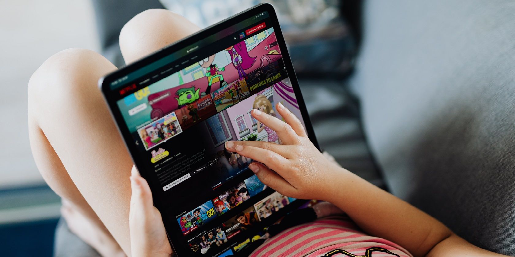 A little girl watching Netflix Kids on a tablet