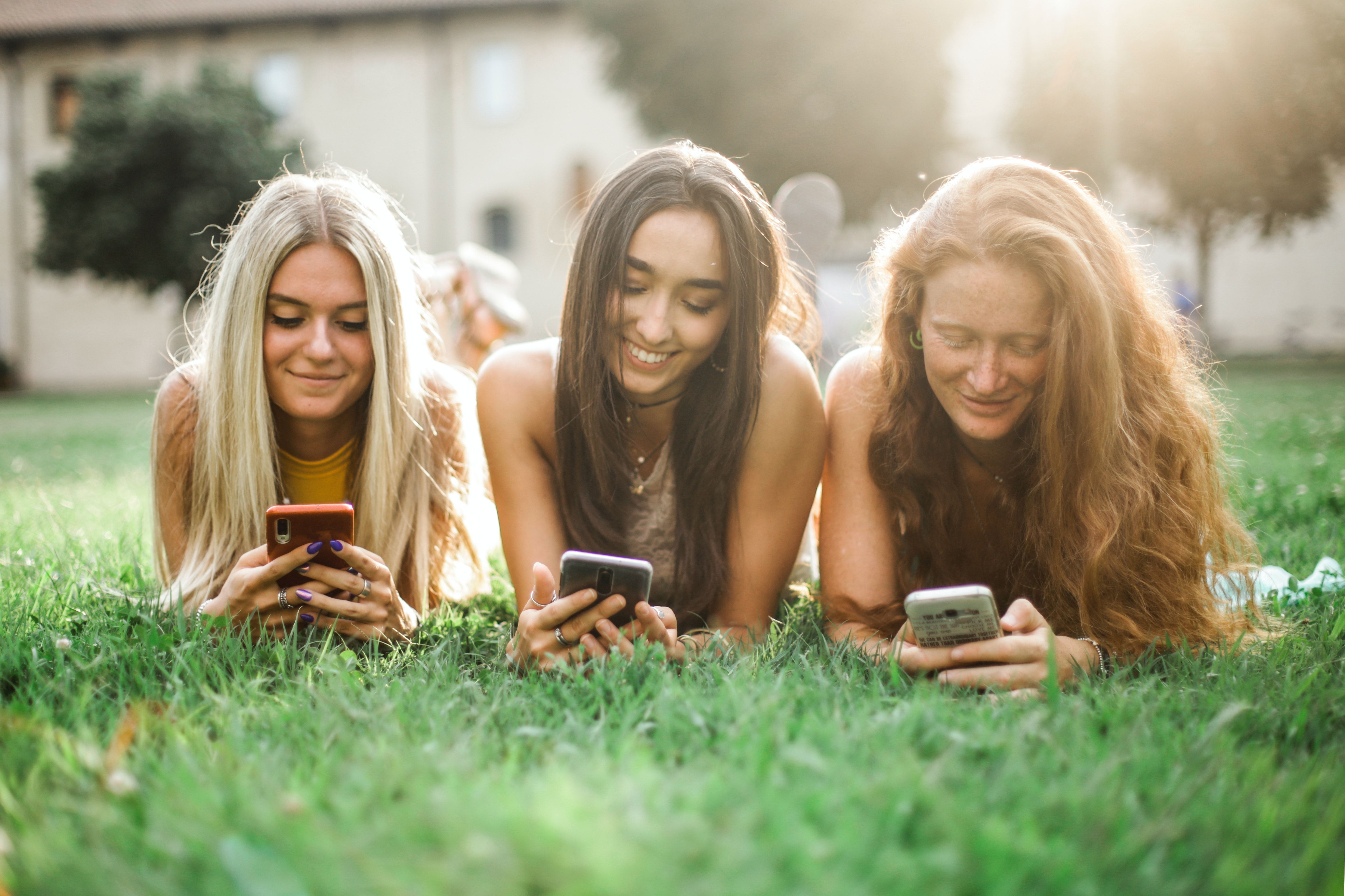 Three girls communicating using social media
