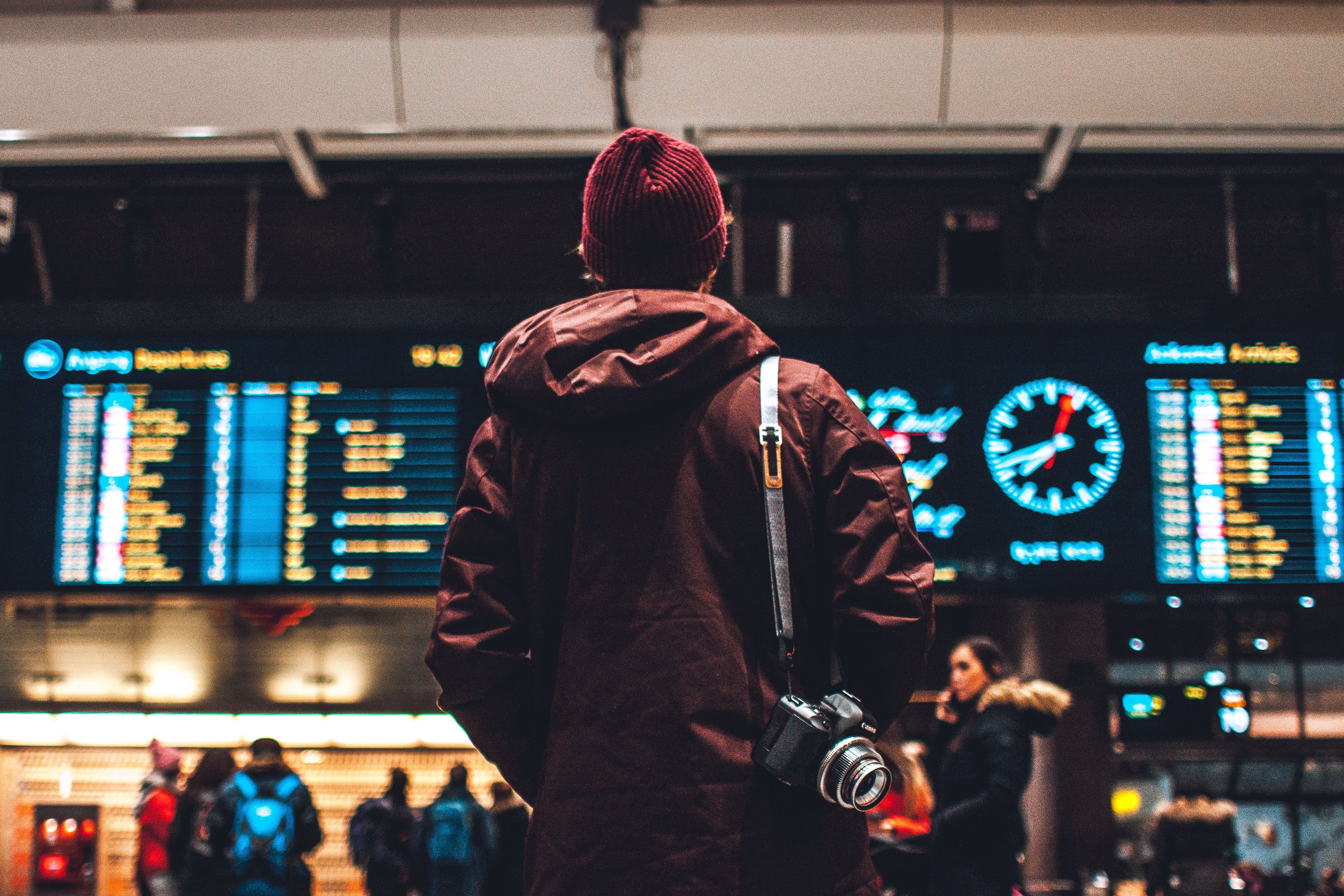 person standing at train station with camera