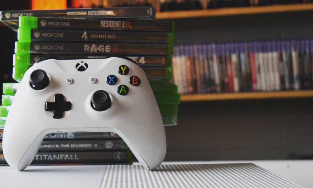 Xbox Controller Beside a Stack of Xbox Games