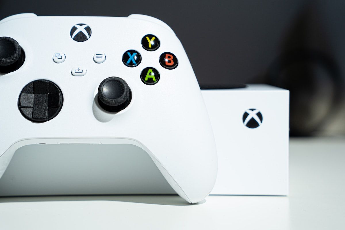 A photograph of the white Xbox Series S console with its white controller in close-up.