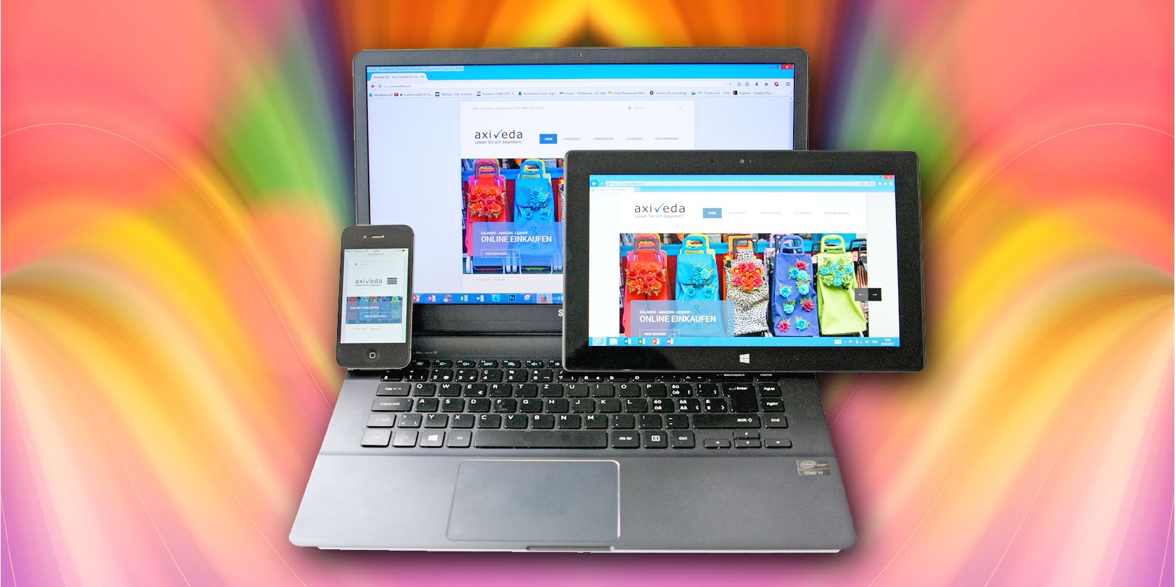 A laptop, tablet, and smartphone in front of a colorful background