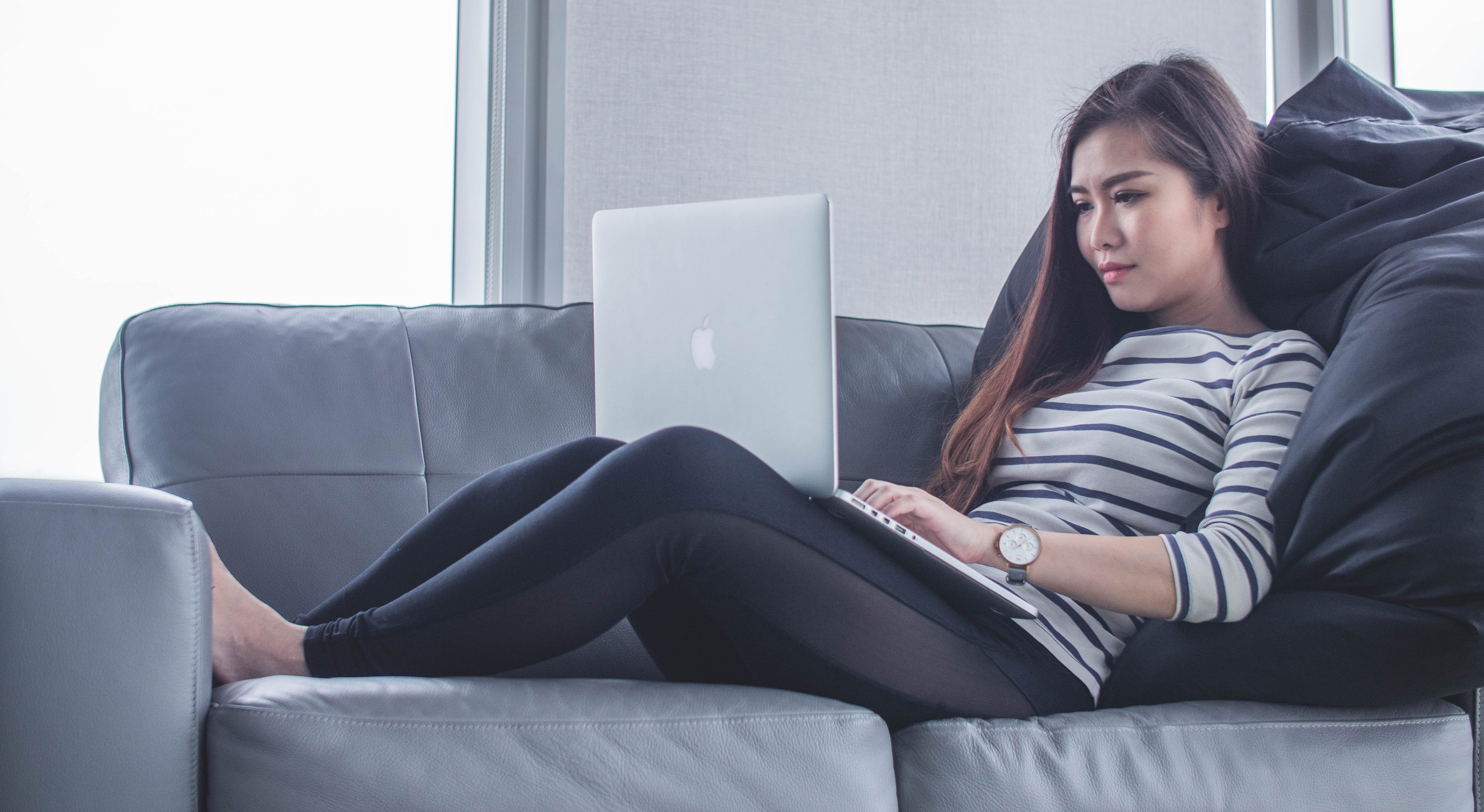 Person on a couch using a laptop