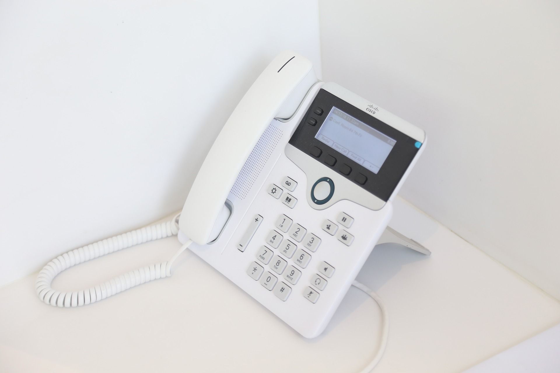 White landline phone sitting in a corner
