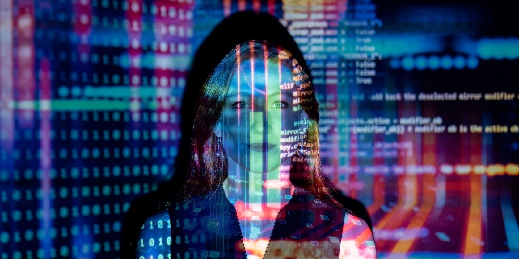 Woman standing in front of a light projection of data and code