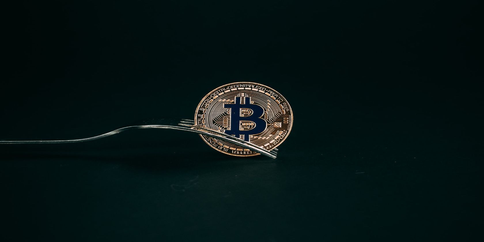 Flickr image of a fork poking through a Bitcoin