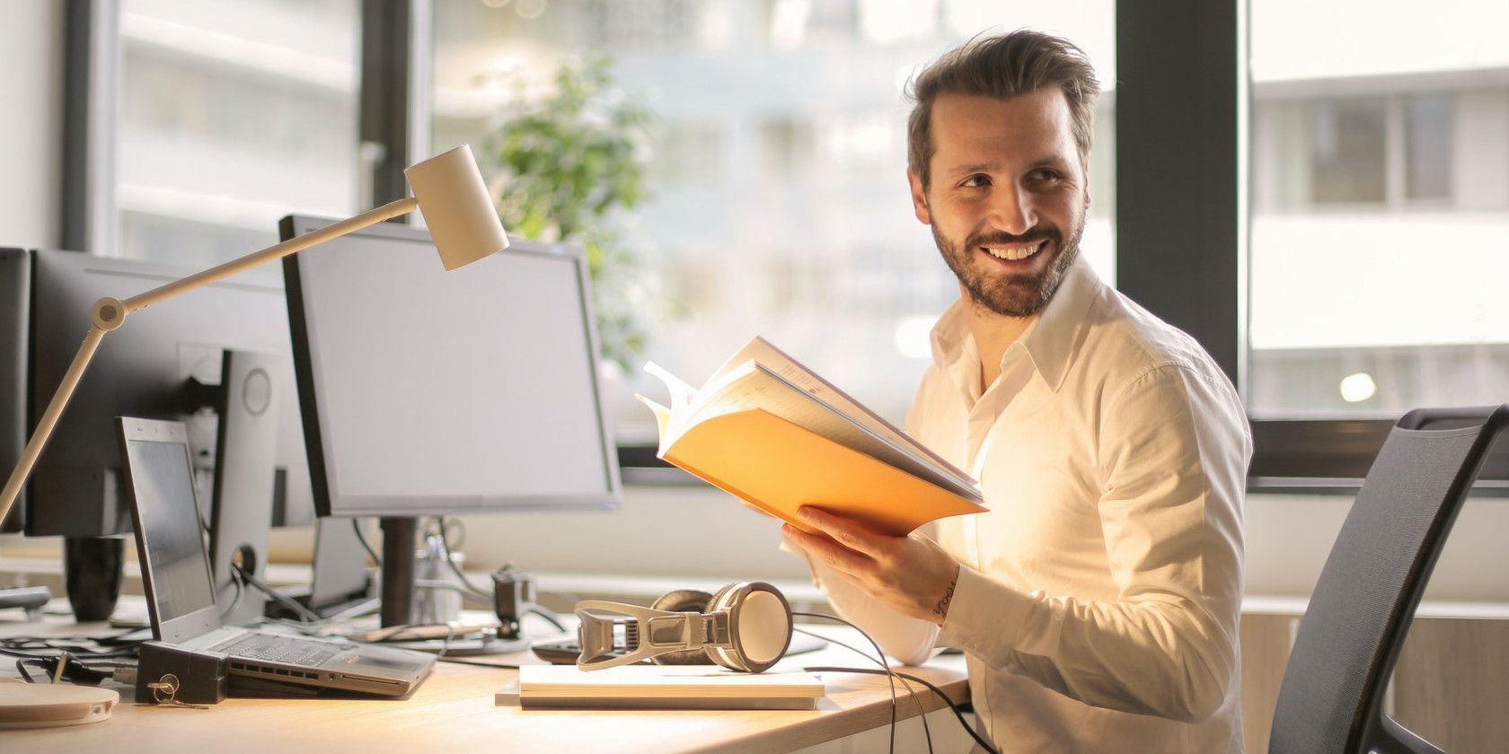 man reading book in office