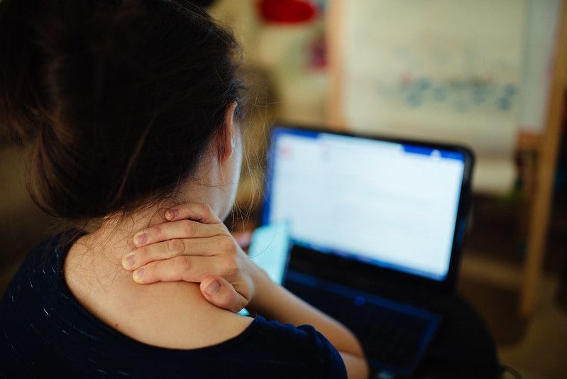 Person with neck pain using a laptop