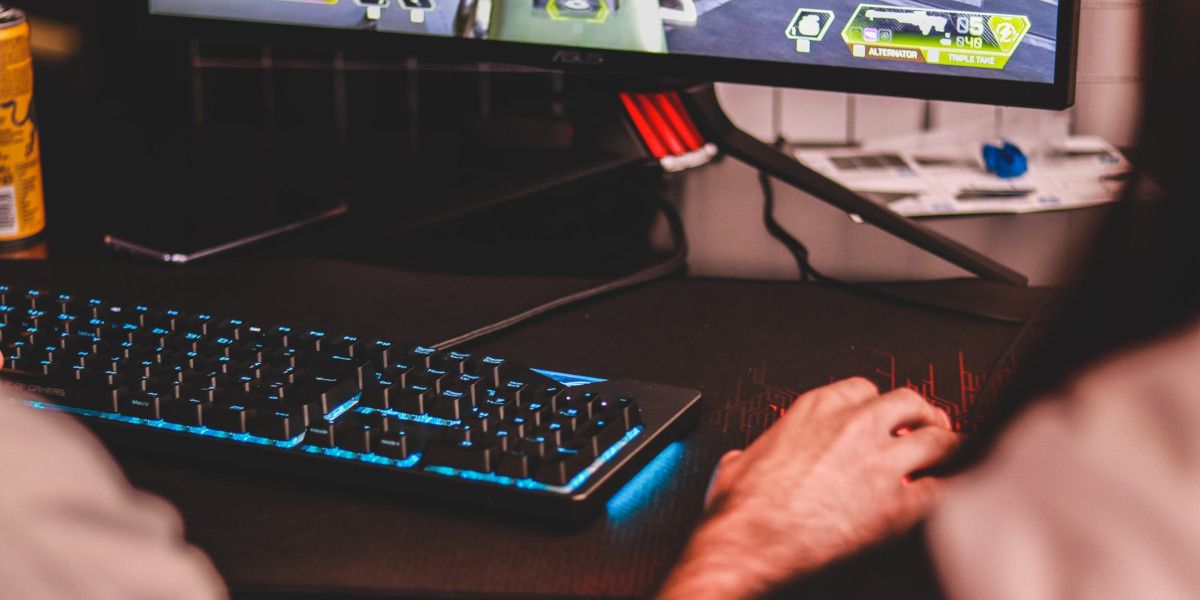 Person Holding a Mouse at a Gaming PC
