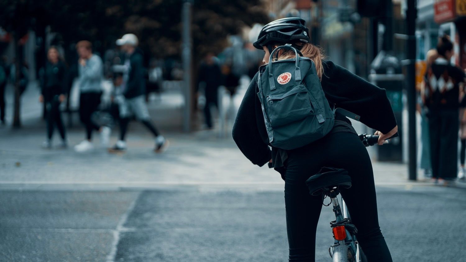 Person riding bike with backpack