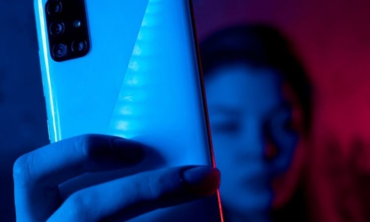 person holding a phone in neon lighting