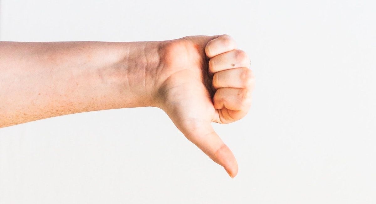 A person giving a thumbs down against a white background
