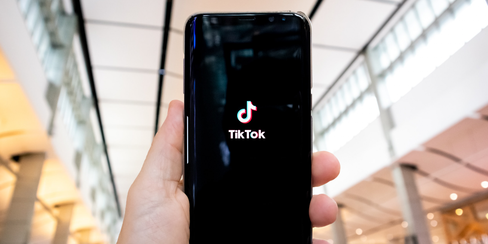 Photo of person holding phone with TikTok screen on it