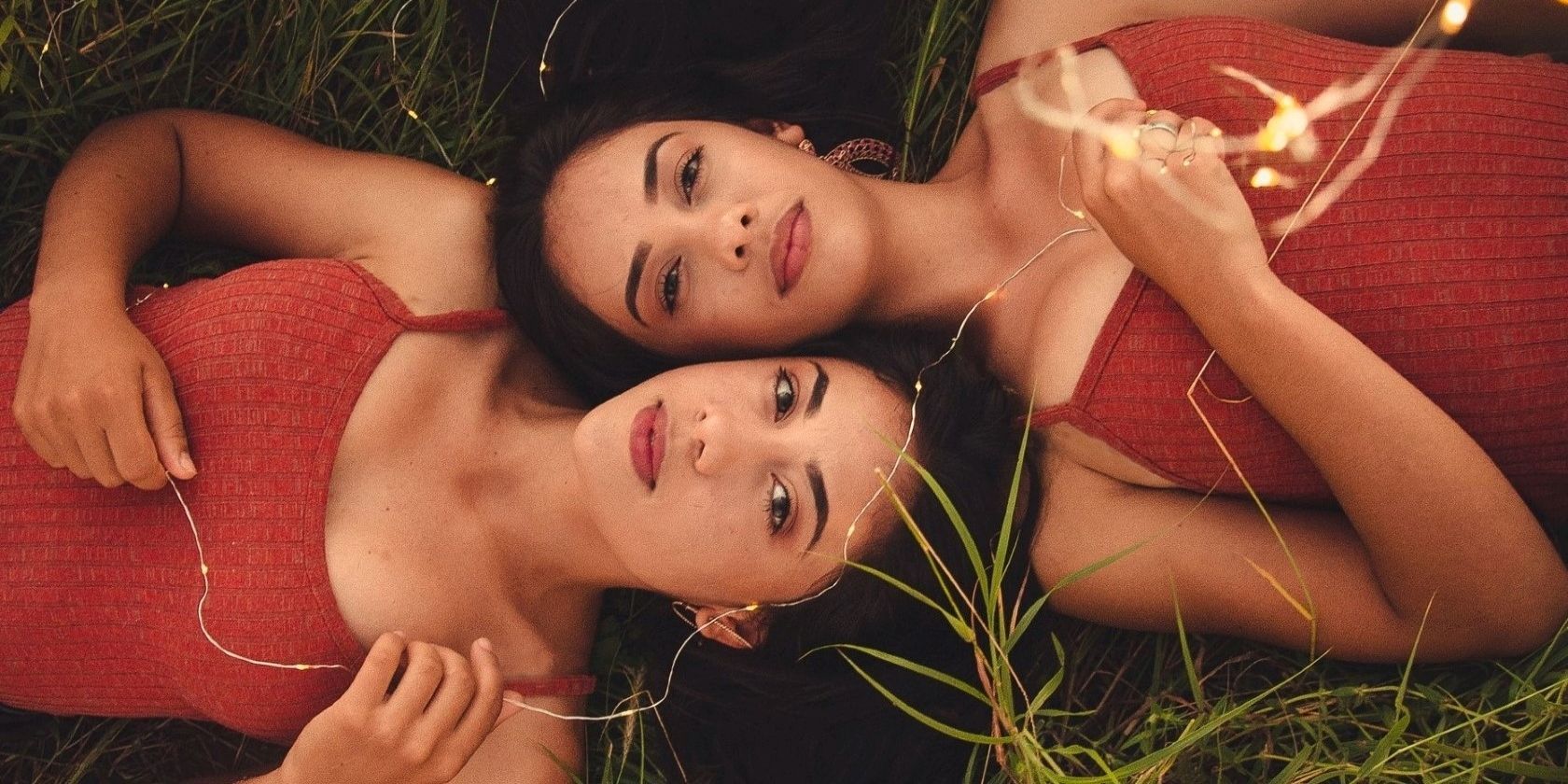 Two twins laying on grass