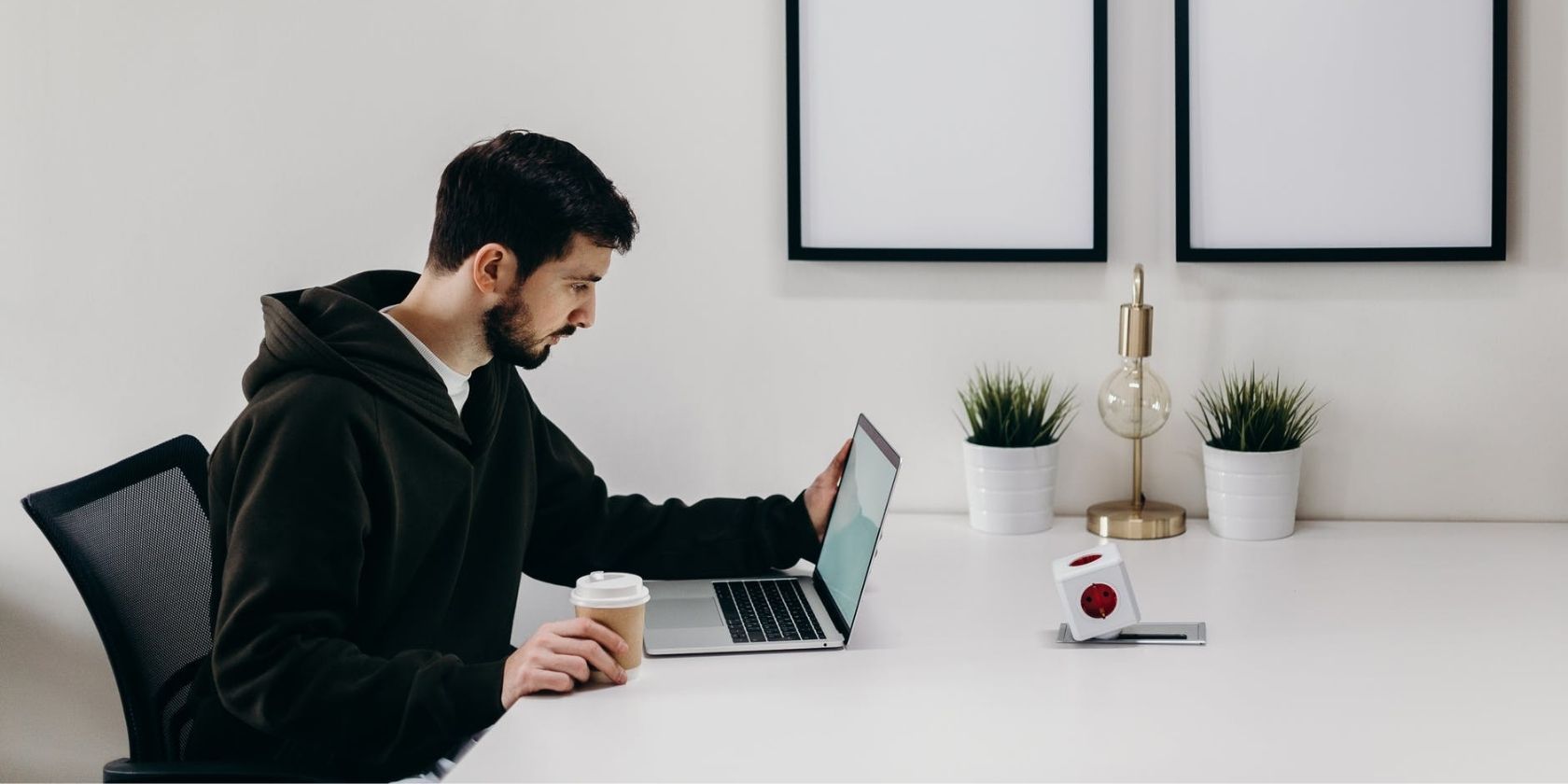 A person looking at a MacBook on top of white desk
