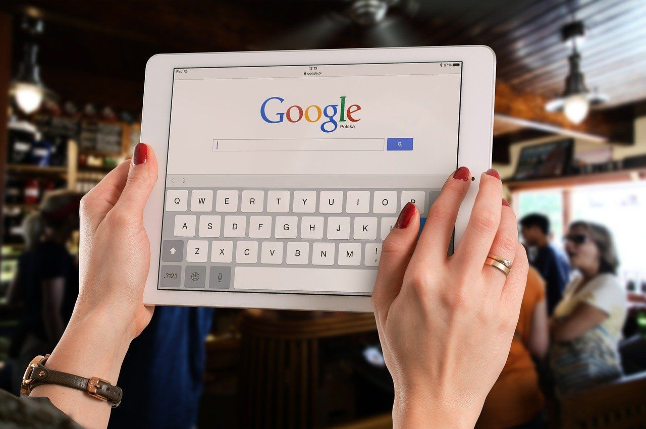 Photo of someone using a tablet with Google's search engine on the screen