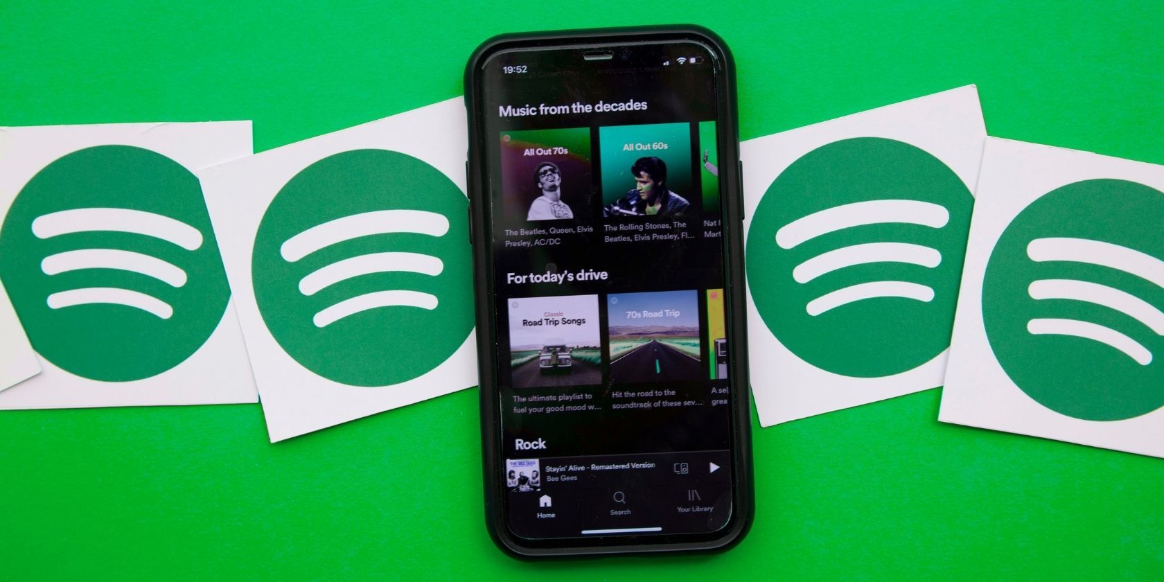 Spotify app on phone in front of Spotify background