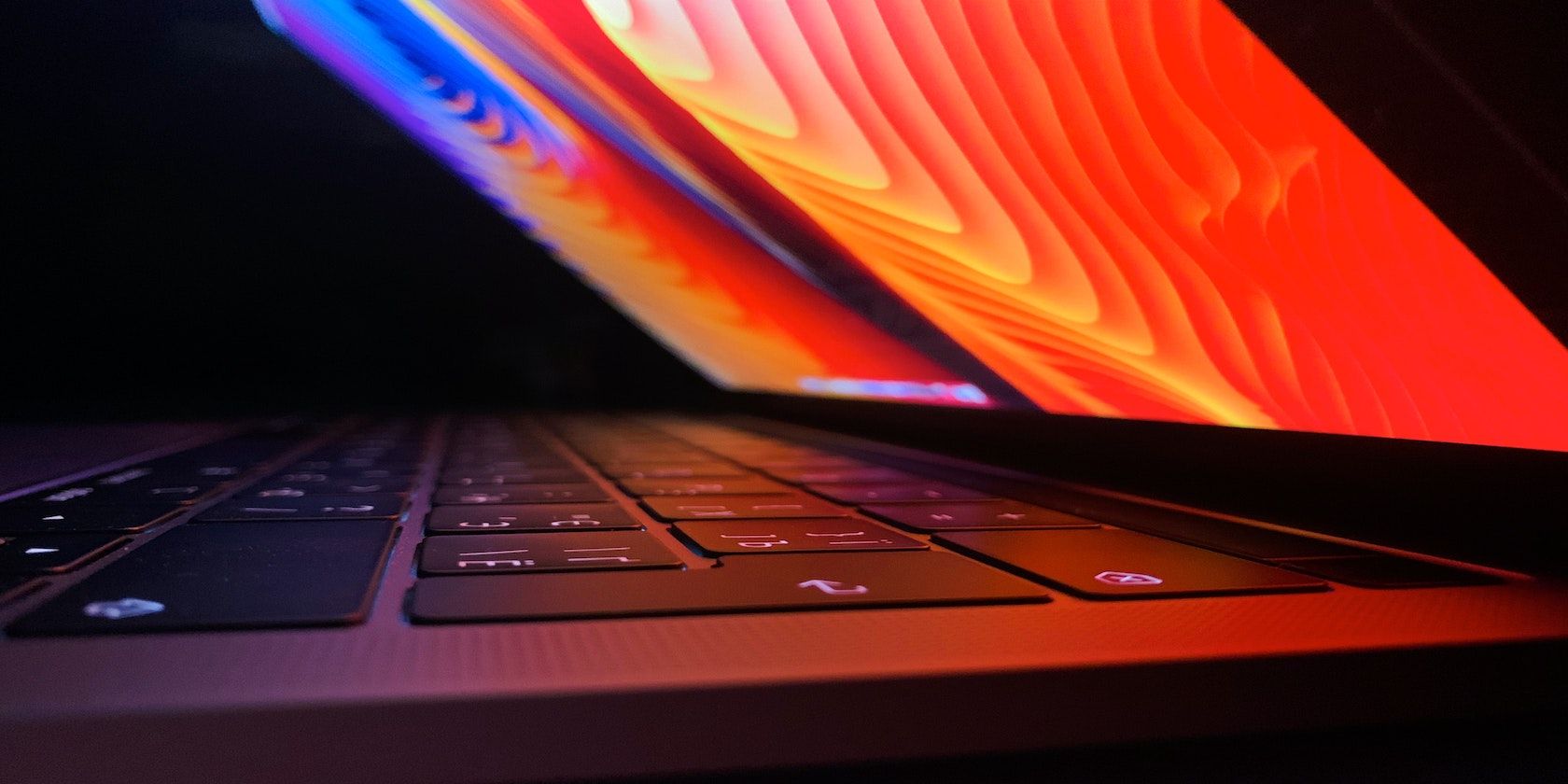 An up close photo of a MacBook Pro with a colorful background