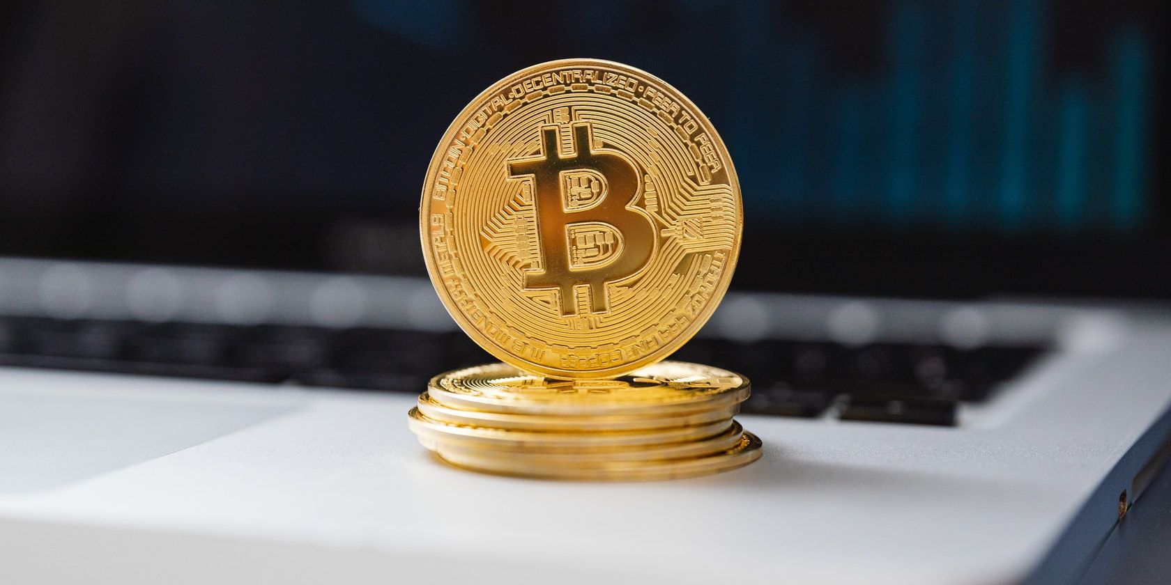 Pexels stock image of a Bitcoin sitting on top of a small stack of bitcoins, on a laptop