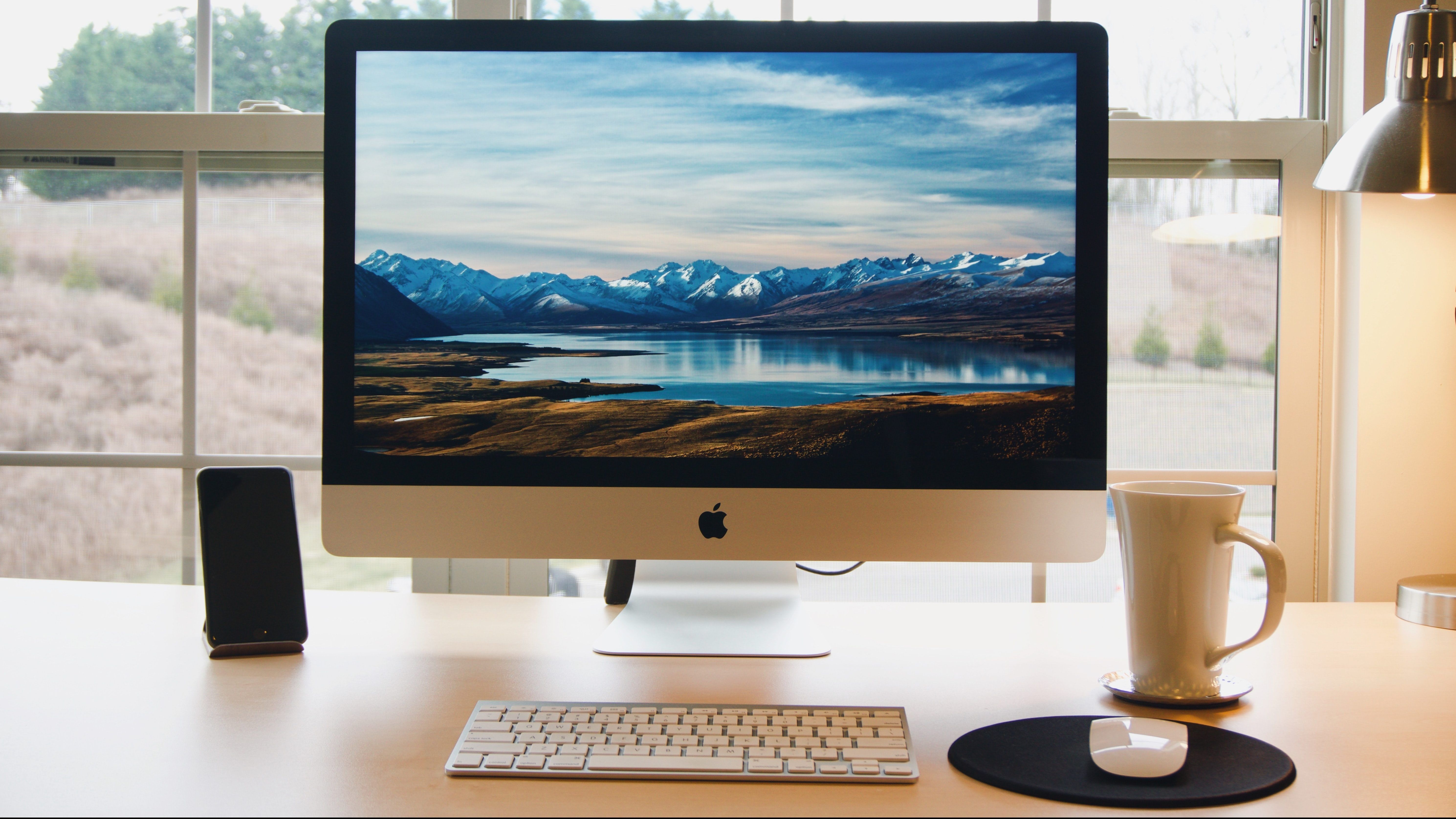 mac on desk with screensaver e1627051567421 - Che cos’è il tasto Alt su Mac? Una guida completa
