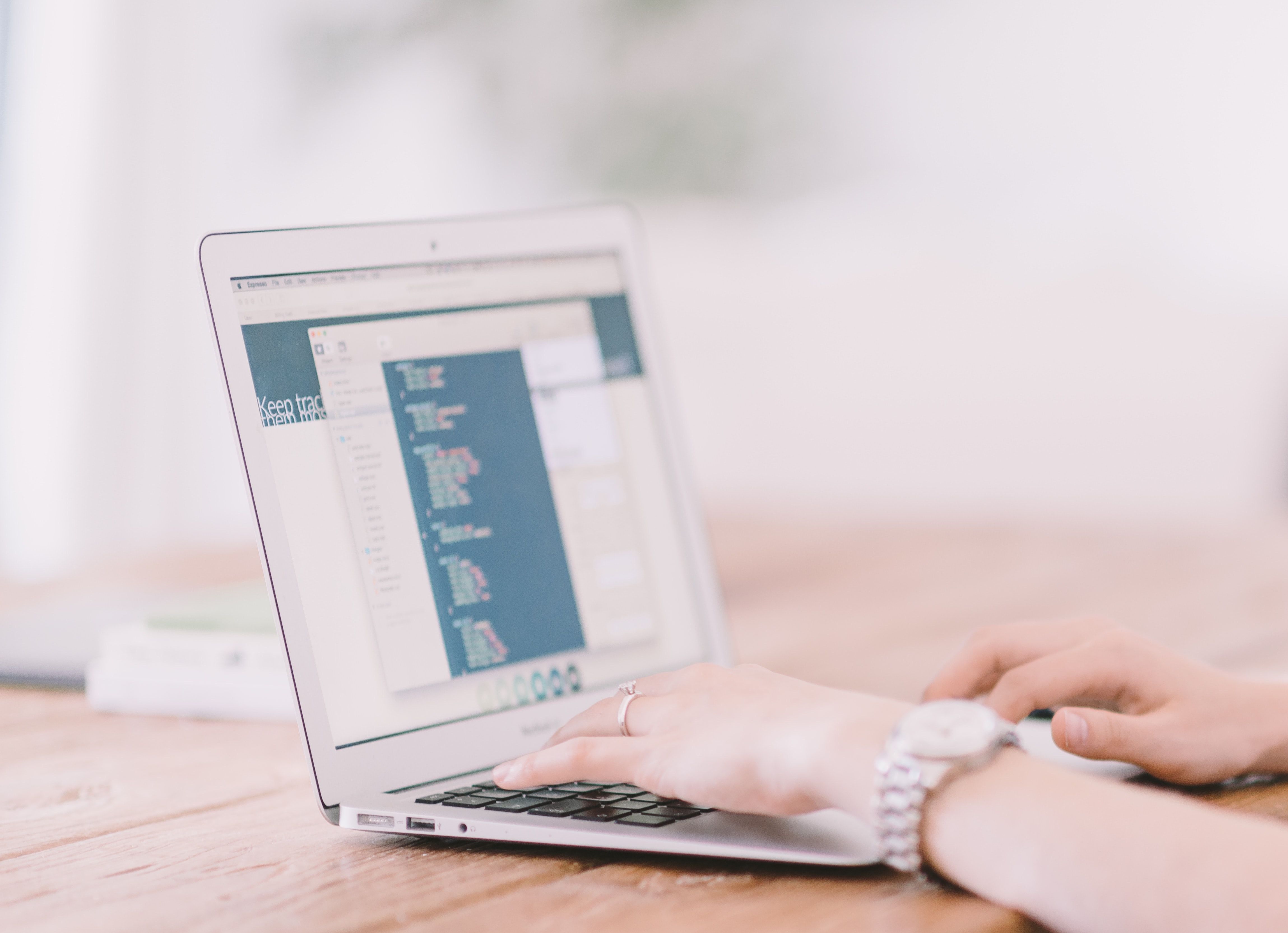 Photo of a person typing on their laptop keyboard