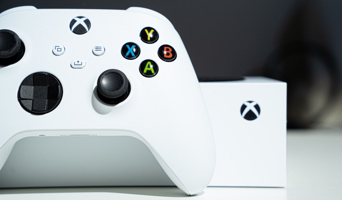 An Xbox Series S and controller on a white table top