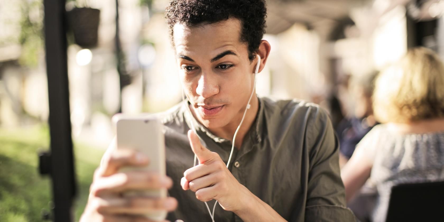 Young man making a video call on phone with earphones on