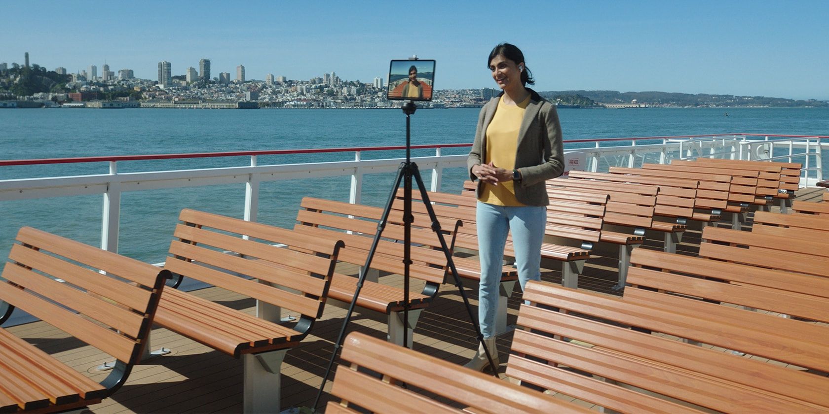 A young woman live-streaming from a boat using her iPad Pro