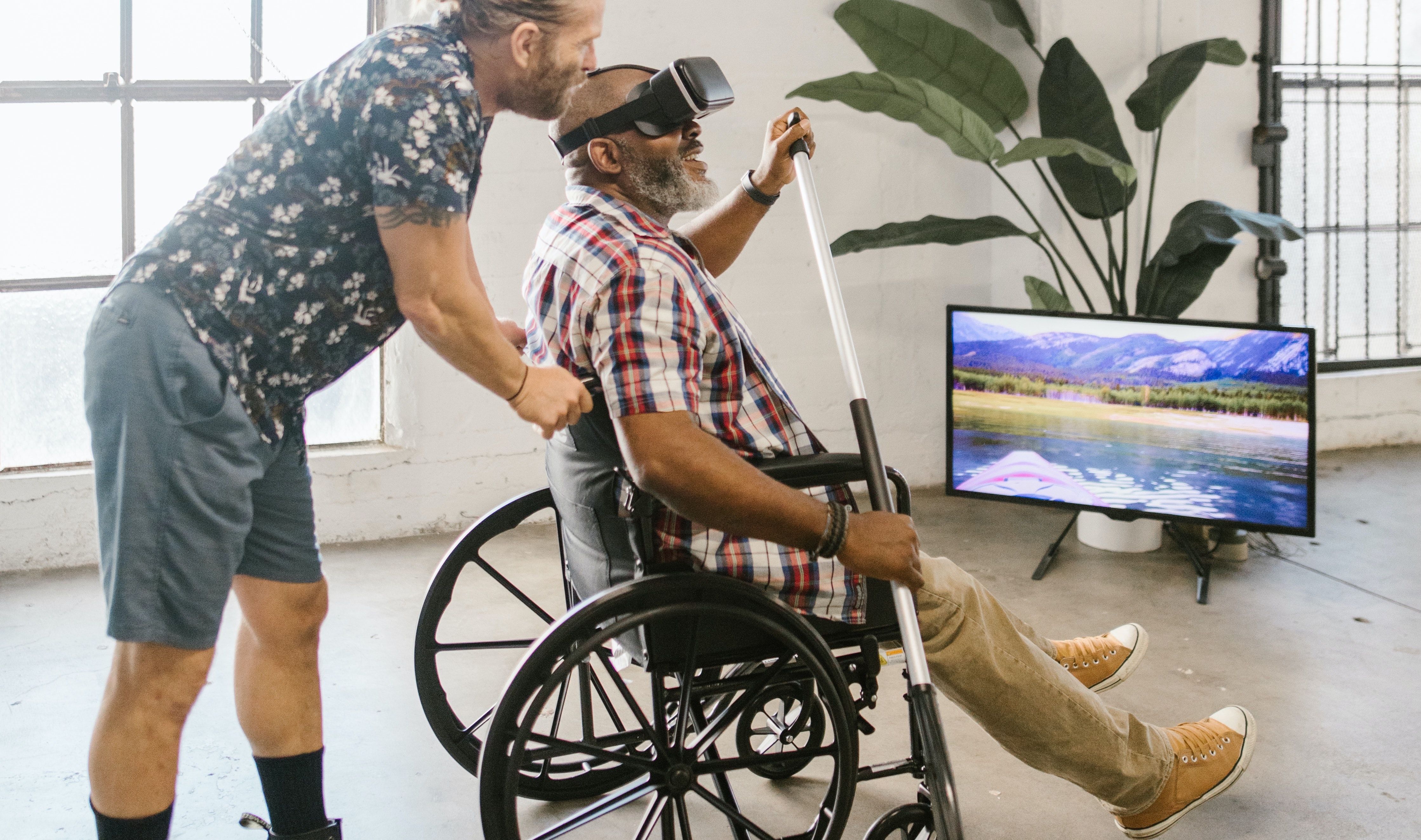 Assistant and Man with VR Headset in Wheelchair