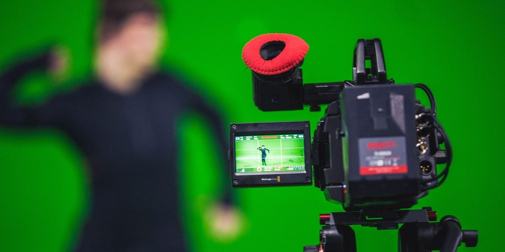 Camera filming someone in fornt of green screen
