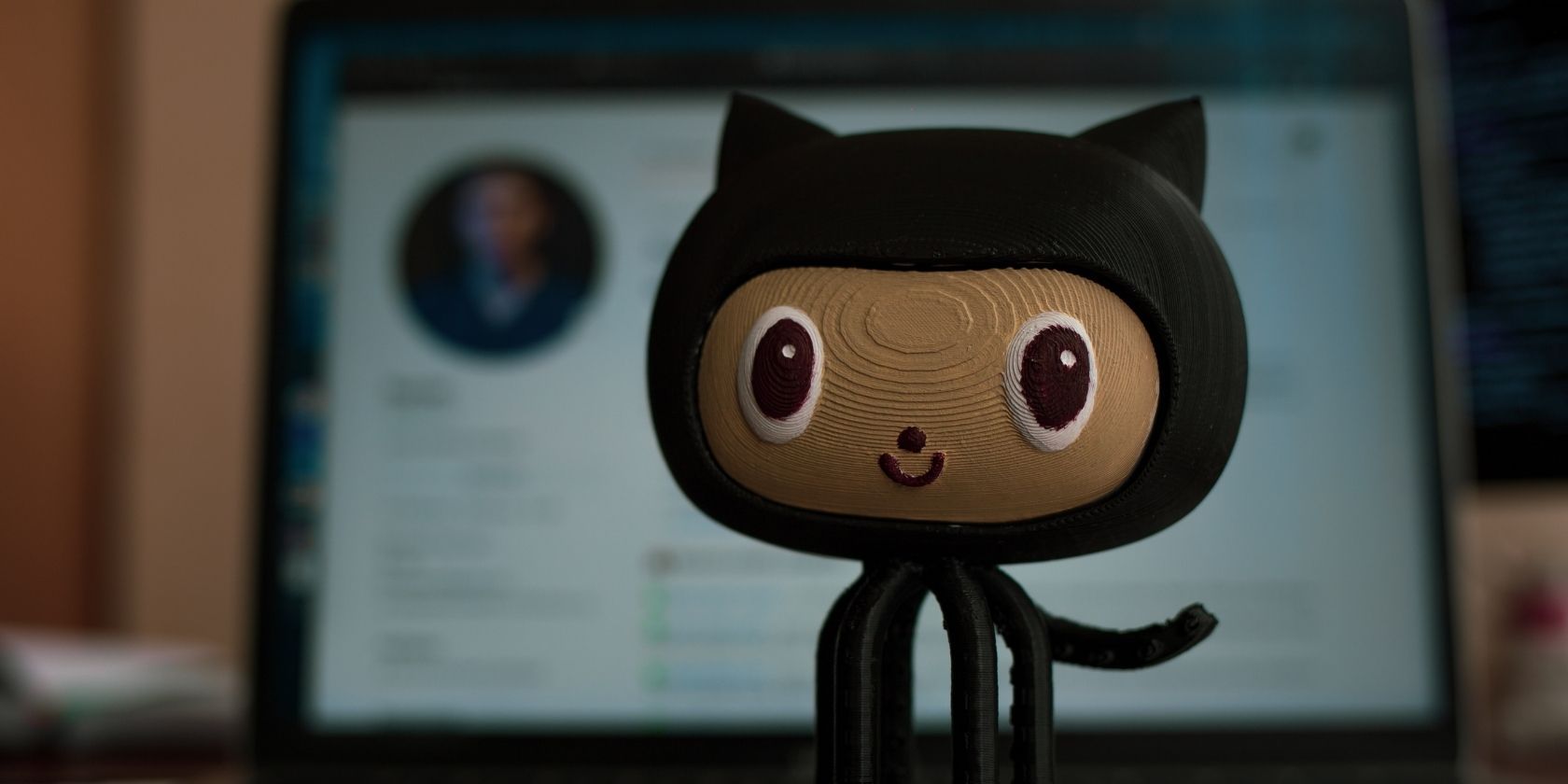 GitHub octocat figurine in front of laptop