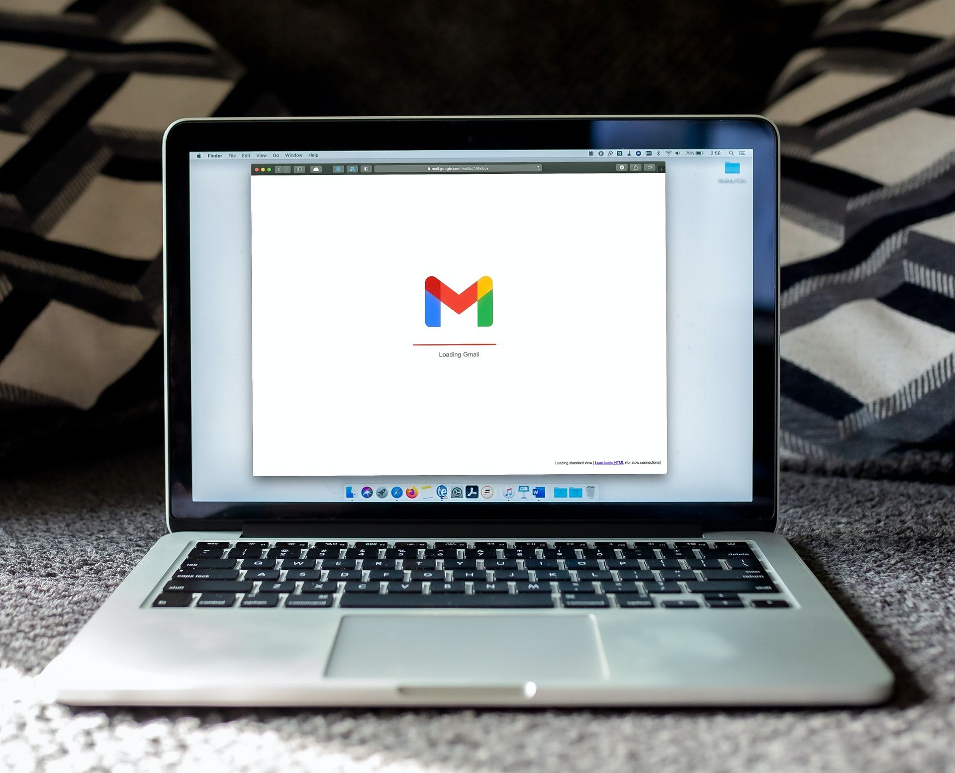 Image shows a laptop screen featuring the Gmail loading screen