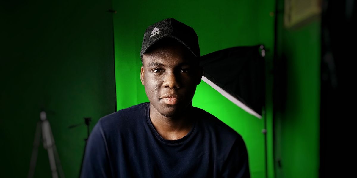 Man in front of green screen with light in background