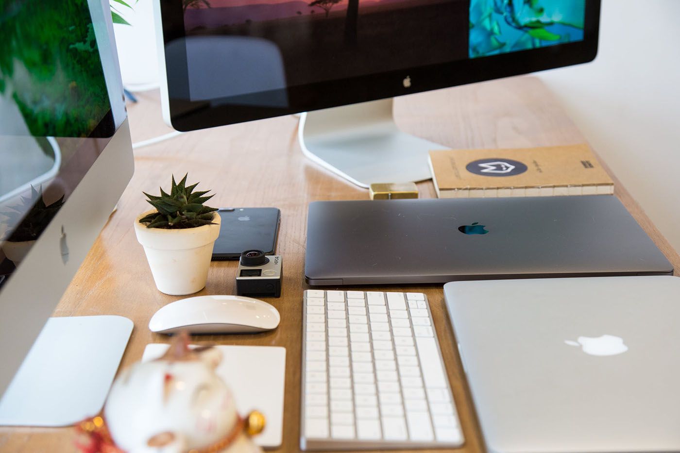 Mac display, iMac, and MacBooks on a desk