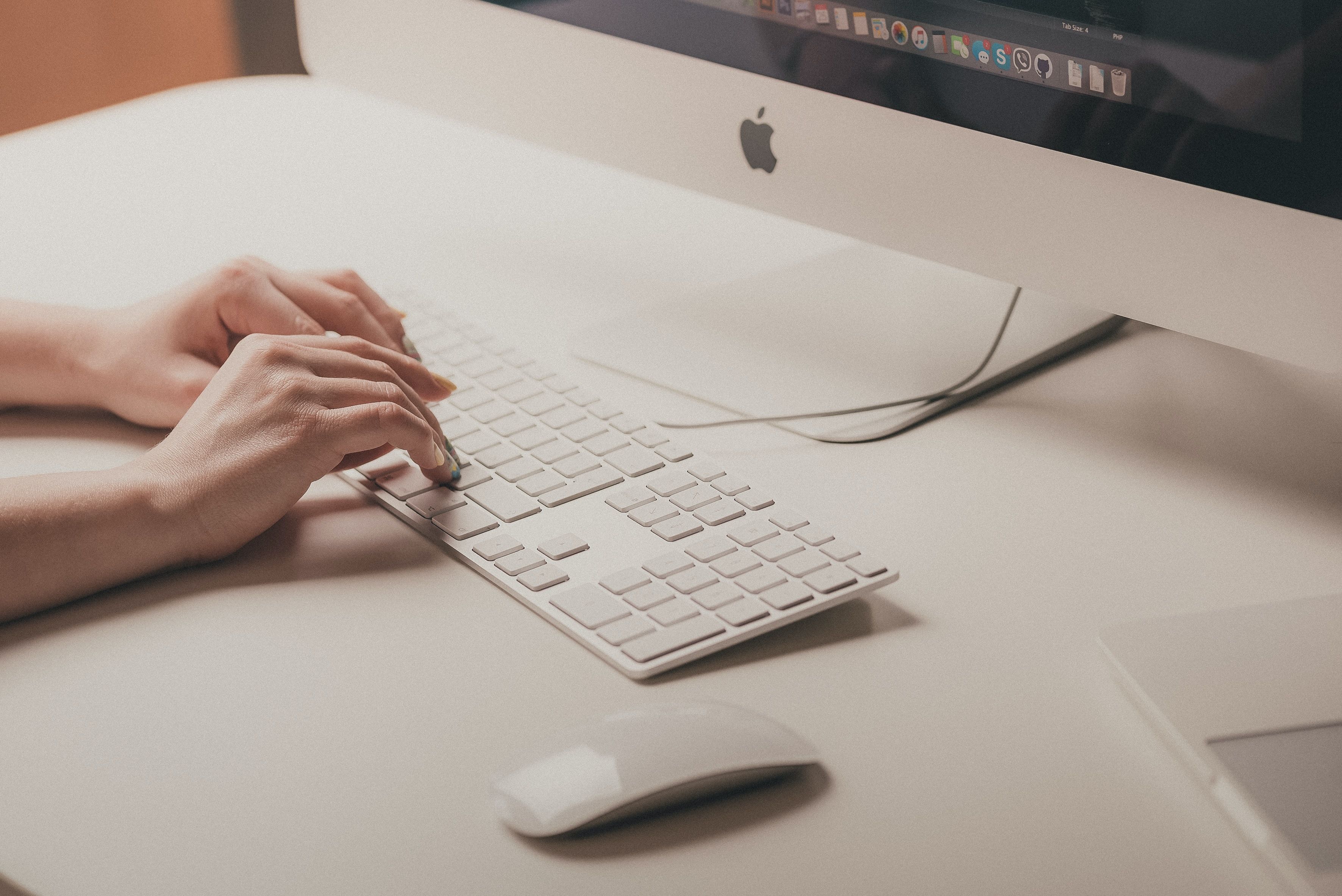 Photo of a person typing on a Mac keyboard