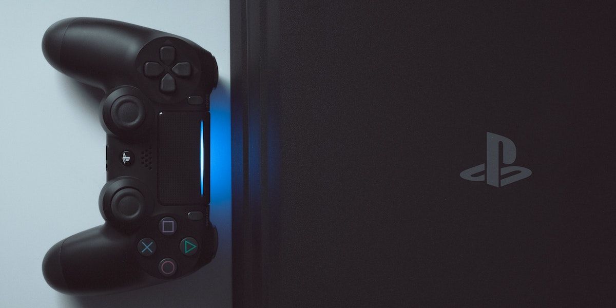 A black PS4 with a controller facing it