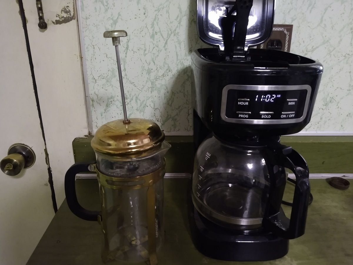 A french press coffee pot next to an electric drip coffee pot